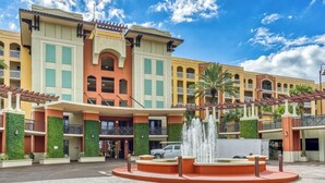 Een hotel met een centrale fontein, meerdere balkons en een binnentuin.