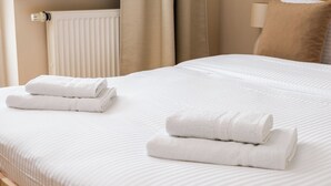A neatly made bed with white linens and two folded towels on the side. - Metro Ursynów Homely Apartment (Warszawa)