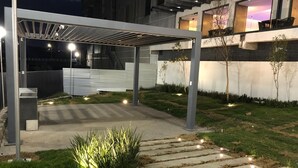 An outdoor patio area with a pergola, stone steps, and low lighting. - 2-bedroom apartment close to comercial area and industrial zones (Qro.)