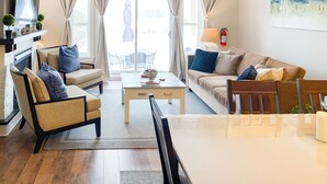 A modern living room with a fireplace, comfortable seating, a coffee table, and a view of the outdoors. - 3 Peaks at Blue Mountains, your luxury staycation! (The Blue Mountains)