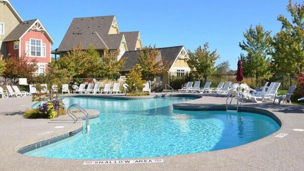 A swimming pool with lounge chairs and a 'Shallow Area' sign. - 3 Peaks at Blue Mountains, your luxury staycation! (The Blue Mountains)