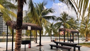 Ein Außenbereich mit Pool, Bänken und Grillplatz.