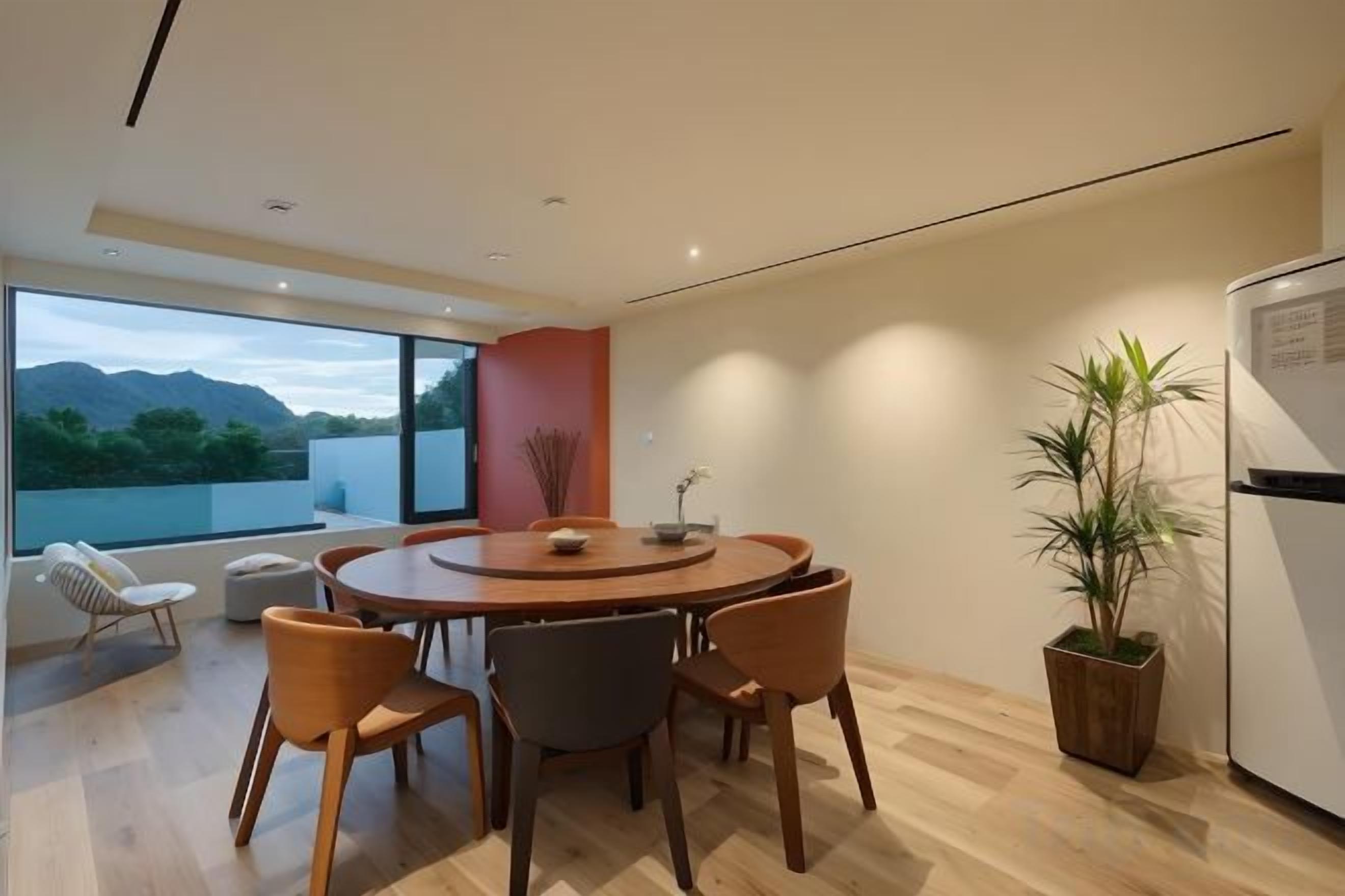 Un espace repas moderne avec une table ronde, des chaises et une plante en pot.