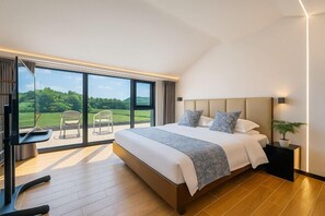 A modern bedroom with a large bed, a TV, and a balcony with chairs. - Yashi Mountain Stream · Children's Swimming Pool Designer Parent Child Vacation Scenic Stay (Hangzhou)