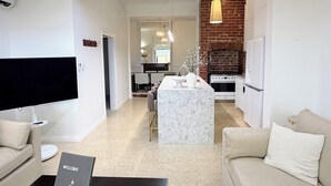 A modern living room with a flat-screen TV, a sofa, a coffee table, and a sign reading 'WELCOME & CO'. - Perfect North Adelaide Location. Walk everywhere! (North Adelaide)