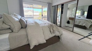 A bedroom with a large bed, a sliding glass door to a balcony, and a mirrored closet. - Perfect North Adelaide Location. Walk everywhere! (North Adelaide)