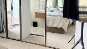 A bedroom with a bed, a TV, a bathroom with a sink, and a sliding glass door leading to an outdoor area. - Perfect North Adelaide Location. Walk everywhere! (North Adelaide)