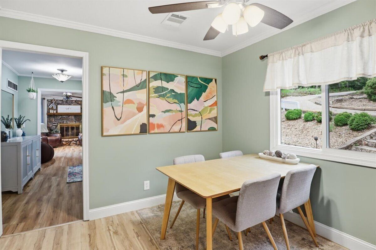Un espace repas comprenant une table, des chaises et un ventilateur de plafond.