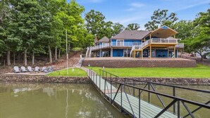 A waterfront property with a house, a dock, and a small docked boat.