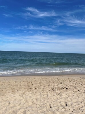 Een strand met een zandrijk strand en rustige golven.