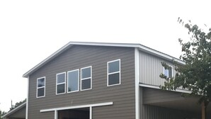 Een tweelaags huis met garage, een overdekte veranda en een stenen fundering.