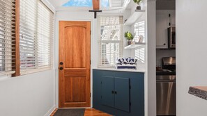 Une cuisine de taille réduite avec une porte en bois, un meuble bleu et une cuisinière encastrée.