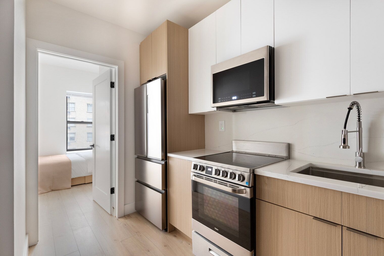A modern kitchen with stainless steel appliances, a built-in oven, and a microwave.
