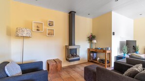 A cozy living room with a fireplace, sofas, a coffee table, and decorative items. - Very Tastefully Furnished Country House for 4 People (Den Burg)