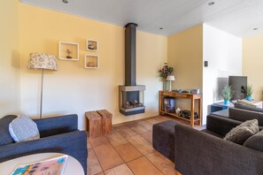 Ein gemütliches Wohnzimmer mit Kamin, Sofas, einem Couchtisch und Dekoration.