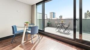 A modern room with a glass balcony, a dining table with chairs, and a view of the cityscape. - GuestReady - Ideal Porto stay near Trindade 4th (Porto)