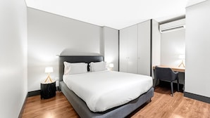 A modern hotel room with a large bed, a desk, and a wardrobe. - GuestReady - Ideal Porto stay near Trindade GF-B (Porto)
