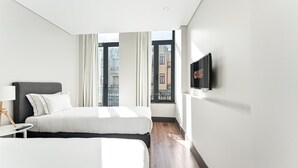 A modern hotel room with a bed, a TV, and a view of the city. - GuestReady - Ideal Porto stay near Trindade GF-F (Porto)