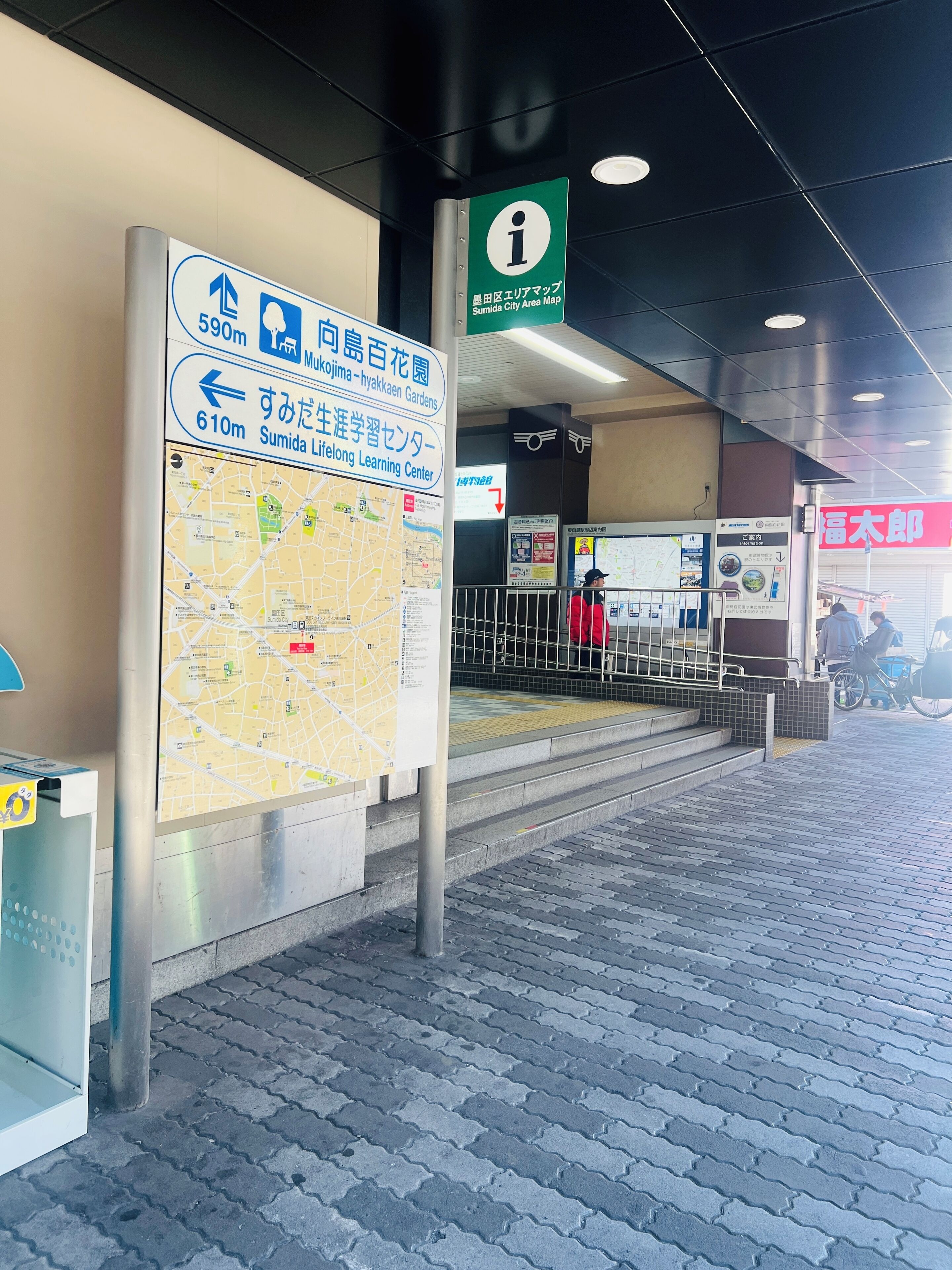 A map and directional signs at a train station entrance.
