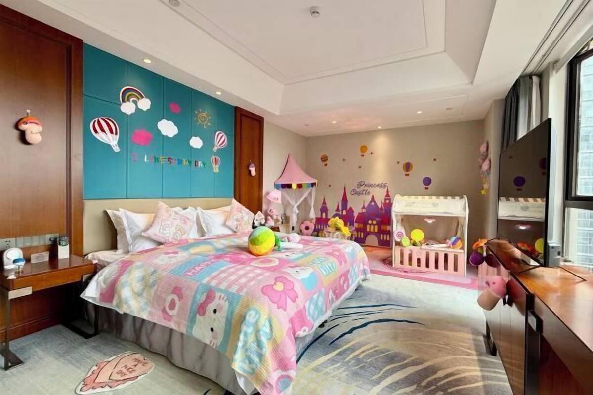 Un dormitorio infantil con cama, una tienda de juegos y adornos en la pared.