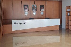 Ein Empfangsbereich mit einem Schild, auf dem 'Reception' steht, und einem polierten Boden.