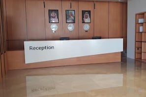 Una recepción con un letrero, paneles de madera y fotografías enmarcadas en la pared.