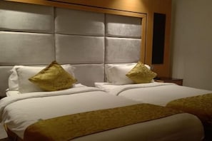 Habitació d'hotel amb un llit gran, dos coixins i un capçal.