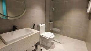 A modern bathroom with a bathtub, toilet, and glass shower enclosure. - Al Rayyan Tower (Jeddah)