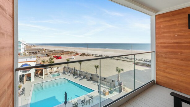 Un balcon avec vue sur la plage et sur l’espace piscine.