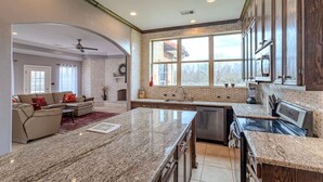 A spacious kitchen with granite countertops, stainless steel appliances, and a large island. - 8BR Ranch house perfect for large families/groups (Rosharon)