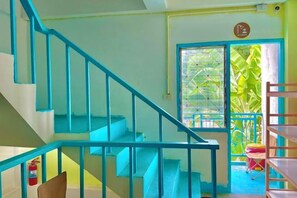 Un escalier avec des rampes bleues menant à une porte dotée d’une fenêtre.