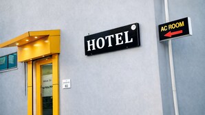 A hotel entrance with a sign indicating the AC room direction. - Kanha Inn (Bhopal)