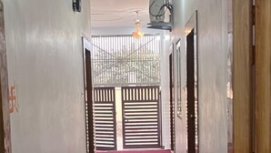 A hallway with a red carpet leading to a gate. - SHRIJI SADAN (Faizabad)