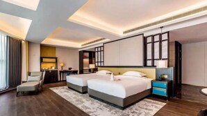 Una habitación de hotel moderna con dos camas, un escritorio y una zona de estar.