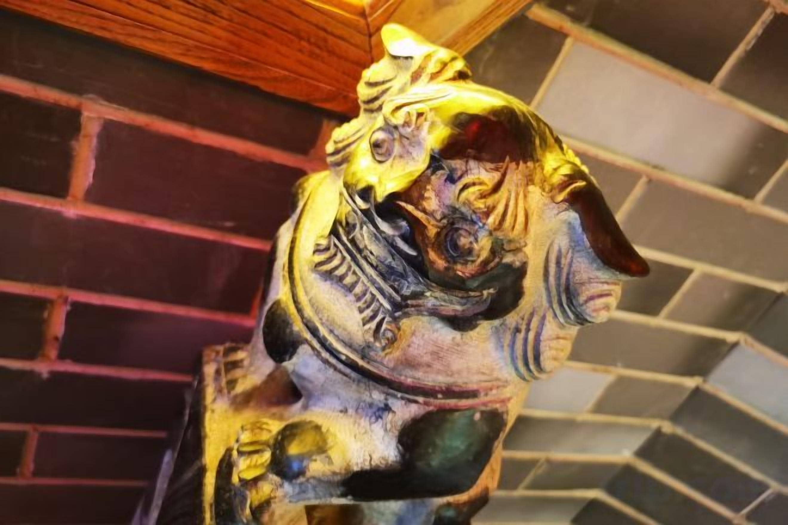 A detailed sculpture of a mythical creature, possibly a dragon, with intricate carvings and a prominent horn.