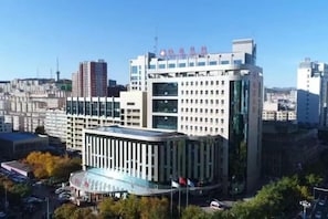 A multi-story building with a modern architectural design, featuring a prominent glass facade and a series of vertical lines on the exterior. - Chengde Hotel (Mountain Resort) (Chengde)