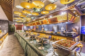 A buffet area with a long counter, multiple food stations, and overhead lighting. - Chengde Hotel (Mountain Resort) (Chengde)