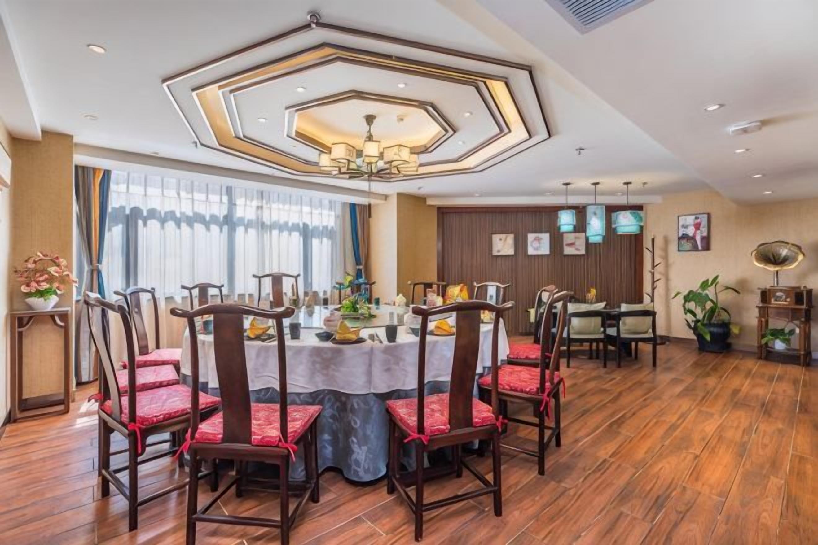 A dining area with a round table, chairs, and a ceiling light fixture.