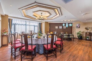A dining area with a round table, chairs, and a ceiling light fixture. - Chengde Hotel (Mountain Resort) (Chengde)
