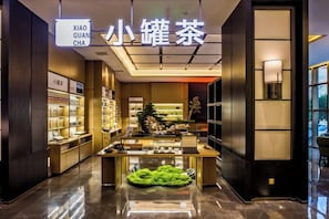 Un aménagement intérieur moderne avec une table centrale servant de présentoir, des étagères remplies de produits et un panneau indiquant le nom de la marque.