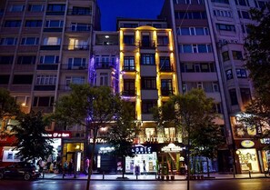 A multi-story hotel with a prominent entrance, balconies, and a well-lit facade. - Royal Garden Suite Hotel (Istanbul)