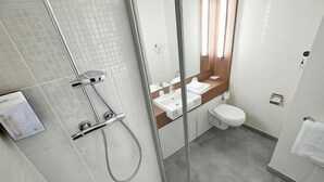 A modern bathroom with a glass shower enclosure, a white sink, and a toilet. - Campanile Aubagne - Alta Rocca (Aubagne)