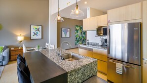 A modern kitchen with granite countertops, stainless steel appliances, and pendant lighting. - Scala 306 1BD Condo for rent in Old Town, Puerto vallarta (Puerto Vallarta)