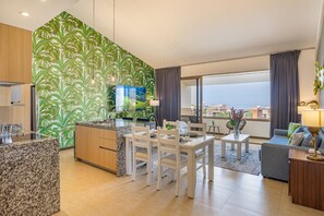 Ein modernes Wohnzimmer mit Küche, Essbereich und einem Balkon mit Blick.