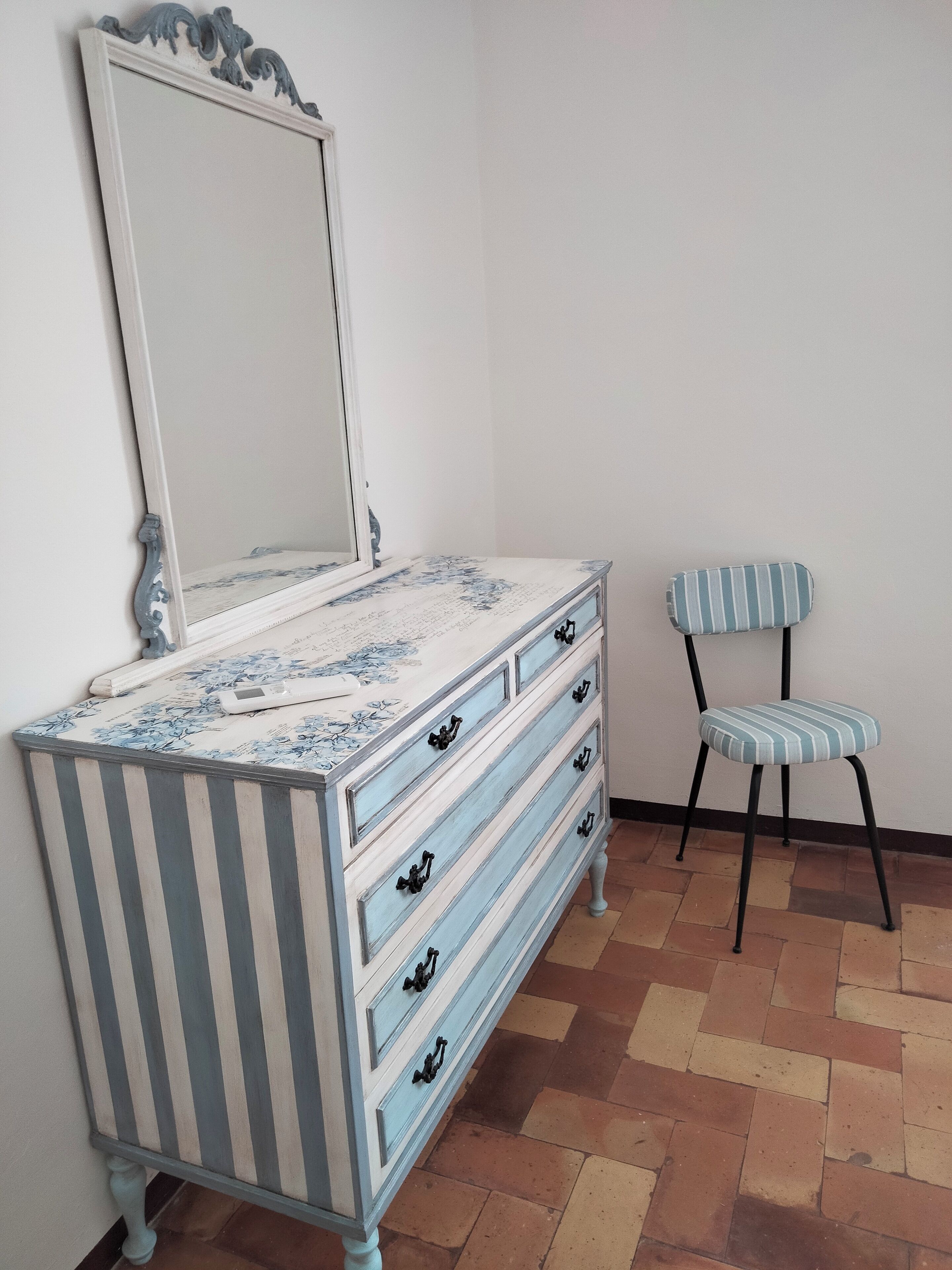 Un aparador con estampado floral y un espejo encima.