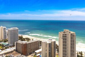 Ein Küstenhotel mit mehreren Hochhäusern, direktem Strandzugang und freiem Blick auf den Ozean.
