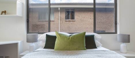 Desk, iron/ironing board, bed sheets