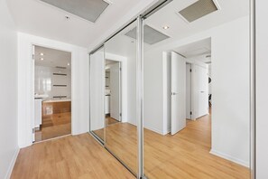 Un interior moderno con un separador de vidrio, suelo de madera y paredes blancas.