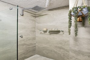 A shower area with a glass door, a towel rack, and a hanging plant. - Chic Urban Paddington Escape (Paddington)