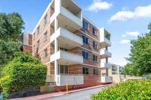 A multi-story apartment building with balconies, brick facade, and a gated entrance. - Silverwater Stay Near Parks and Cafés (Silverwater)